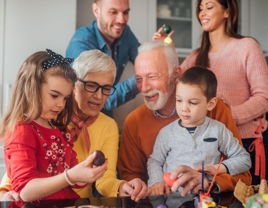Grandparents with their adult children and grandchildren celebrating Easter.
